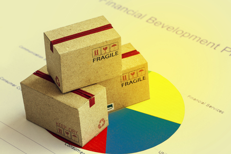 Closeup shot of three cardboard paper boxes and this type of financial charts include stacks of bar compare between the expansion of export business and increase the rate of goods each year.の写真素材