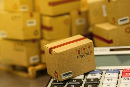 business concept: Small cardboard boxes and calculator. Concept of Increasing product rates the expansion of export business to plan marketing or finance go future. which expected return is maximized.の写真素材