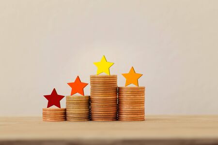 Arrange five star shape on rows of rising coins on table. The best excellent business services rating experience concept.の写真素材