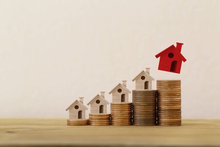 Arrange red outstanding small house or home on stacks of coins, Property investment real estate /...
