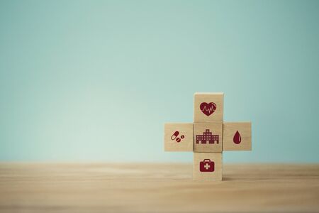 Healthcare concept about of health and medical insurance, arranging wood block stacking with icon healthcare medical on table wooden background.の写真素材