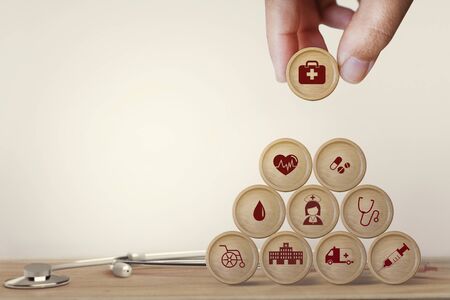 Healthcare concept about of health and medical insurance, Hand arranging block sphere stacking with icon health care medical on table wooden background.の写真素材