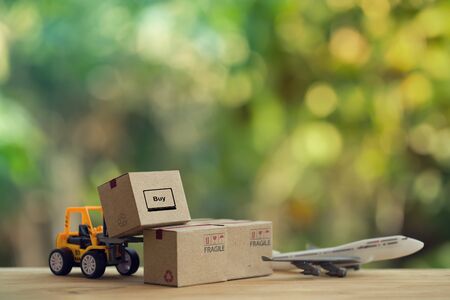 Logistic and cargo freight concept: Fork-lift truck moves a pallet with Paper boxes, plane. depicts delivery management from the point of origin to point of consumption according to needs of customersの写真素材