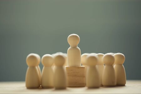 Successful business team leader concept: Businessman standing at the highest point on wooden block...