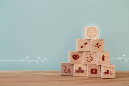 Healthcare concept about of health and medical insurance, arranging wood block stacking with icon healthcare medical on table wooden background.の写真素材