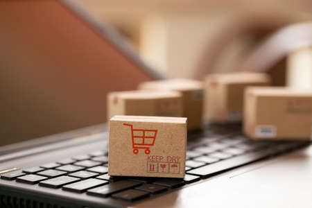 Shopping online, e-commerce concept: Cardboard boxes on keyboard. depicts of transportation that can be done easily using an online internet.の写真素材