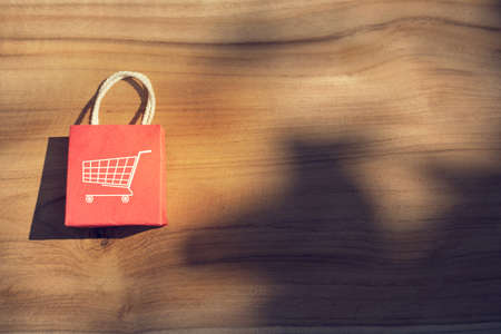 Online shopping concept: shopping bags on wooden table. E-commerce is the purchase of products and services on the internet can purchase goods or services foreign country.の写真素材
