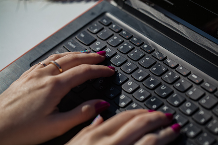 Girl working on laptop, hand close-upの写真素材