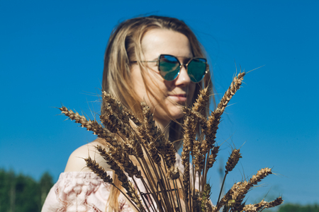 Girl walking on the field with wheatの写真素材