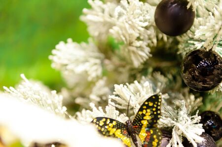 Black christmas ball on the white tree in the background with other decorations and garlands copy space.の写真素材