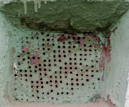 Old wall rusty ventilation grate with small holes.の写真素材