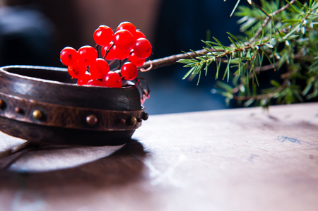Winter scene with fresh green branches of pine, holly, juniper, cones, star, red berries of barberry in natural wooden planter on bark weathered background, outdoors and space, daylightの写真素材