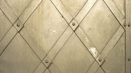 fragment of grey iron gate with rivets, close-up shotの写真素材