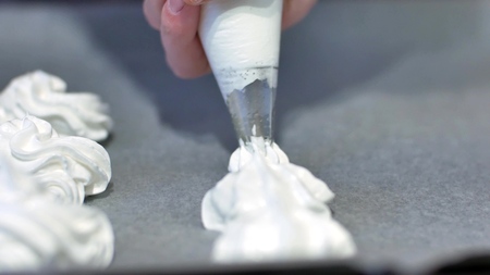 Meringue is laid out on a baking sheet, homemade pastries, cake, cookies made at home meringues