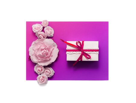 Gift box present decorations flatlay. Gift red ribbon pink white flowers top view Congratulation template banner frame white box purple paper copy space backdrop mockup invitation design greeting cardの写真素材