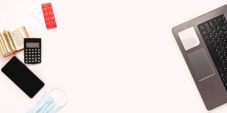 Home office computer laptop smartphone dictionary medical mask tablets pills strips top view template long banner.の写真素材