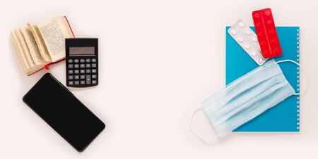 Home office smartphone, dictionary, medical mask, tablets pills strips on whiteの写真素材