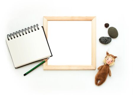 Flat lay mock up, top view, wooden frame, toy squirrel, pencil, note pad, stones. Interior layout, square poster mockup, wood frame, white background. Retro template poster, picture, art painting.の写真素材