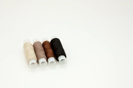 Flat lay colorful cotton thread spools, embroidery yarn, white, brown, black, bobbins, mock up, top view. Layout mockup, blank white background needlework, sewing poster, banner. Empty space for text.の写真素材