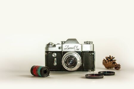 Old retro camera, color lens mock up blank white background. Closeup interior home white poster mockup with space for text. Retro template for poster, picture. White table, blank space, vintage cameraの写真素材