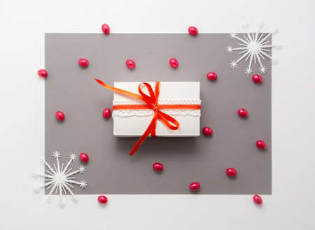2020 Merry christmas decorations flatlay. Gift, red ribbon, snow flakes, top view. New year template frame on gray paper, copy space. Xmas concept backdrop for invitation design, greeting card, bannerの写真素材