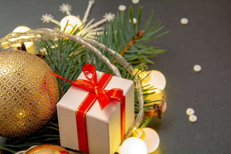 2021 New Year Christmas decorations close up. White gift box red ribbon golden balls spruce branch...