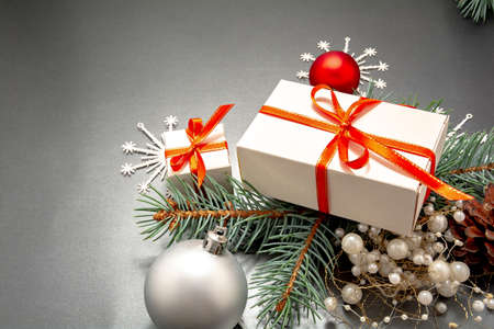 2021 Happy New Year, Merry Christmas decorations flatlay. Gift boxes, red ribbon, balls, spruce branch, snowflakes top view. Boxing Day banner template, black paper, copy space. Xmas concept mock up.の写真素材