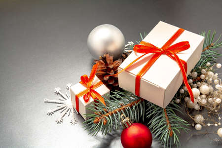 2021 Happy New Year, Merry Christmas decorations flatlay. Gift boxes, red ribbon, balls, spruce branch, snowflakes top view. Boxing Day banner template, black paper, copy space. Xmas concept mock up.の写真素材