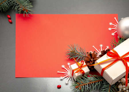 2021 Happy New Year, Merry Christmas decorations flatlay. Gift boxes red ribbon, balls spruce branch snowflakes top view. Boxing Day banner template black red paper copy space. Xmas concept mock up.の写真素材