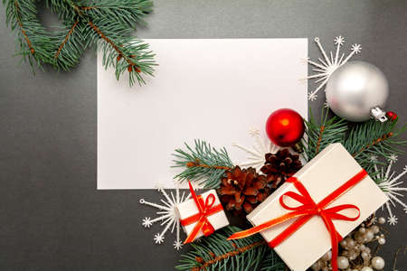 2021 Happy New Year, Merry Christmas decorations flatlay. Gift boxes, red ribbon, balls, spruce branch, snowflakes top view. Boxing Day banner template, black paper, copy space. Xmas concept mock up.の写真素材