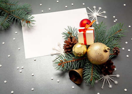 2021 New Year Christmas decorations flatlay. Gift box ribbon golden balls spruce branch pinecone bell snowflakes top view. Boxing Day banner template black white paper copy space. Xmas concept mock upの写真素材