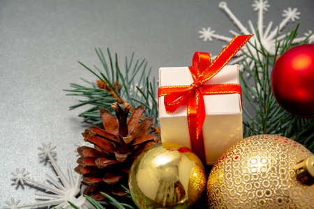 2021 New Year Christmas decorations close up. Gift box red ribbon golden balls spruce branch pinecone snowflake. Boxing Day banner template black paper copy space. Xmas concept mock up selective focusの写真素材