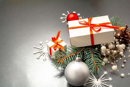 2021 Happy New Year, Merry Christmas decorations flatlay. Gift boxes, red ribbon, balls, spruce branch, snowflakes top view. Boxing Day banner template, black paper, copy space. Xmas concept mock up.の写真素材