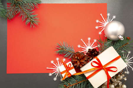 2021 Happy New Year, Merry Christmas decorations flatlay. Gift boxes red ribbon, balls spruce branch snowflakes top view. Boxing Day banner template black red paper copy space. Xmas concept mock up.の写真素材