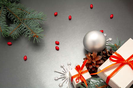 2021 Happy New Year, Merry Christmas decorations flatlay. Gift boxes, red ribbon, balls, spruce branch, snowflakes top view. Boxing Day banner template, black paper, copy space. Xmas concept mock up.の写真素材