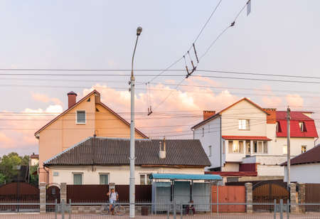 Old white cottage in cozy town. Street view landscape old cirty, little houses on sunset. Old architecture street front view. Calm old town street. Stone white pink rural cottages and summer gardens.の写真素材