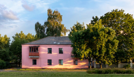 Old white cottage in cozy town. Street view landscape old city, little houses on sunset. Old architecture street front view. Calm old town street. Stone white pink rural cottages and summer gardens.の写真素材