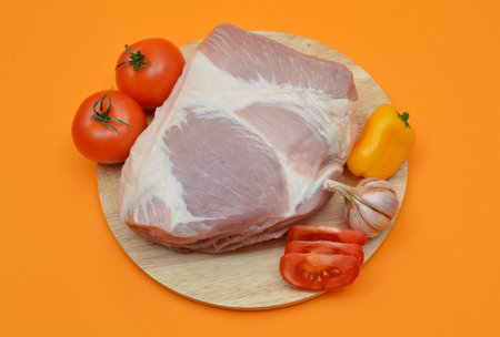 Pork with vegetables on an orange background.の写真素材