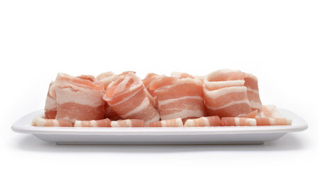 Rolled bacon isolated on white. Side viewの写真素材
