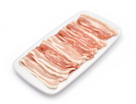 Slices of bacon on a white plateの写真素材
