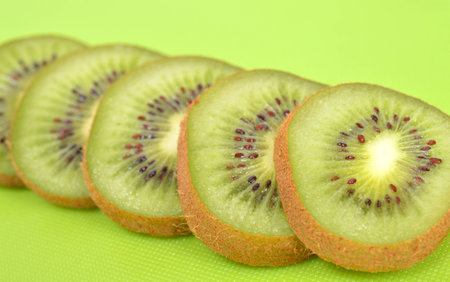 Kiwi slices closeup on a green backgroundの写真素材