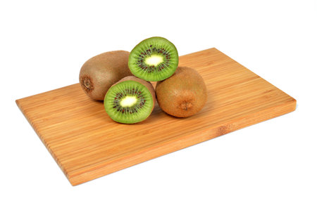Kiwi on a bamboo board isolated on whiteの写真素材