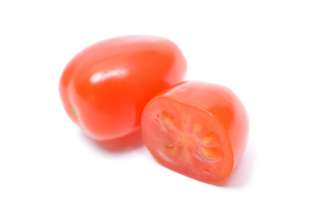 Cherry tomatoes cut in half isolated on white backgroundの写真素材