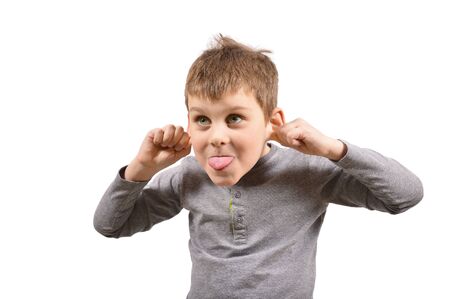 Small cheerful boy shows his tongue and pulls back his ears.の写真素材