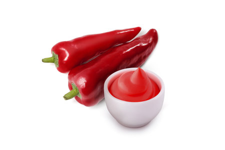 Sauce bowl with ketchup and chili peppers isolated on a white backgroundの写真素材