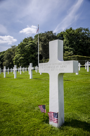 White headstone of an unknown soldier and US flagsのeditorial素材