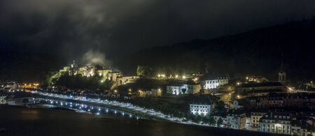 View of Bouillon Castle lit up at night with a cloud of mist haning over itのeditorial素材