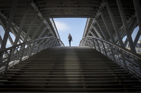 PARIS, FRANCE, 20 MAY 2012 - Solitary lady walking up the steps of the passerelle Leopold-Sedar-Senghor, formerly known as passerelle Solferino (or pont de Solferino), a footbridge over the River Seine in Parisのeditorial素材