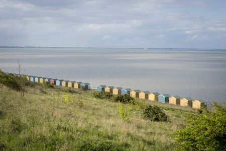 The rear of a row of beach huts looking out to sea. Isle of Sheppey Kent UK
