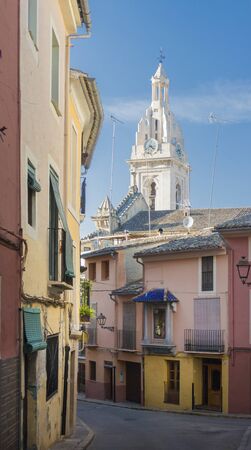Narrow street and tower of La Seu Cathedral, Xativa (Jativa), Valencia, Spainの写真素材